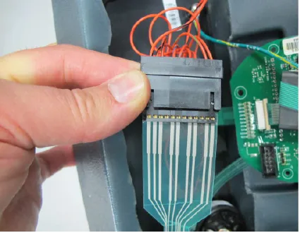 Hand holding the ribbon connector for the control switches next to the circuit board