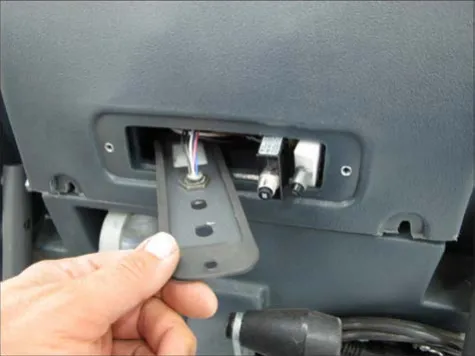 Hand pulling the circuit breaker mounting plate partway out of the cover opening