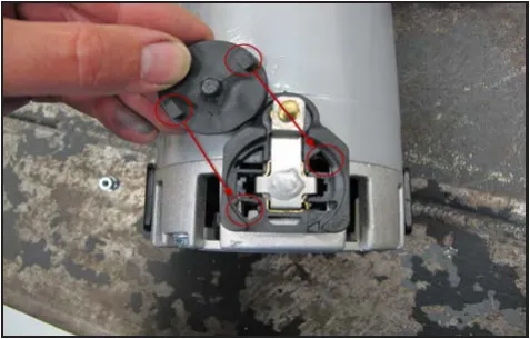 Photo of the brush cap being lined up with the brush holder, with red circles and lines marking the two locking tabs.