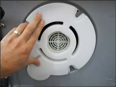 Hand holding the white vacuum motor cover in place over the motor