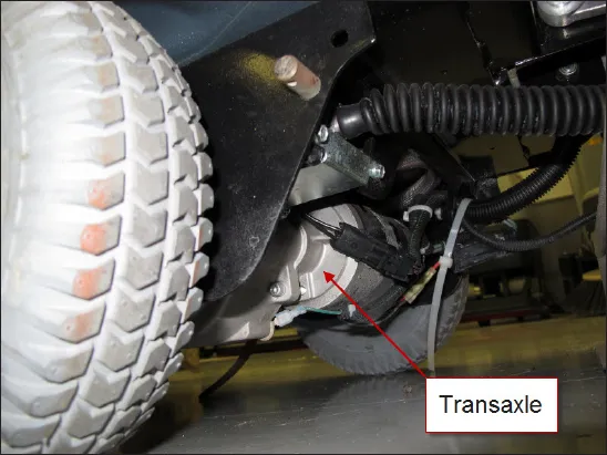 Photo of the transaxle (wheel drive motor) behind the drive wheel, with an arrow labeled Transaxle
