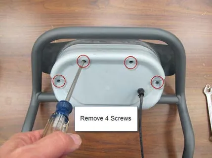 Photo of the back of the paddle on a bench with the four front cover screws circled and a label reading Remove 4 Screws