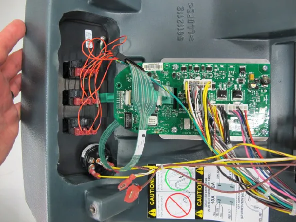Electrical panel cover with the circuit board, ribbon cable, wiring harness, circuit breakers and key switch visible