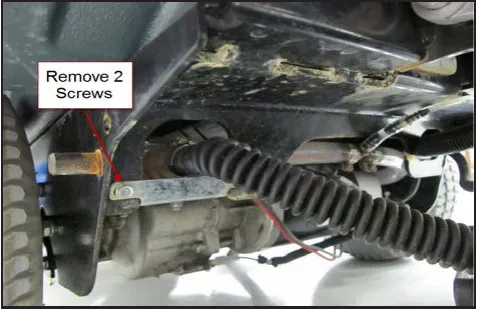 Photo under the machine with an arrow from the label Remove 2 Screws to the solution mounting plate screw