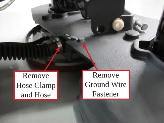 Photo of the brush head with an arrow to the solution hose clamp labeled Remove Hose Clamp and Hose, and an arrow to the ground wire fastener labeled Remove Ground Wire Fastener.