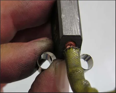 A carbon brush with its wire lead, held with a spring