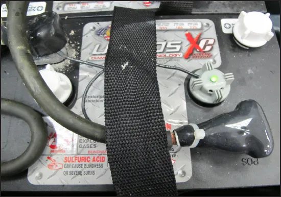 Battery fill indicator installed in place of a fill cap on a battery, with the green LED lit