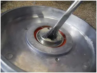 Photo of a brush applying anti-seize to the bore of the eccentric in the driver motor.