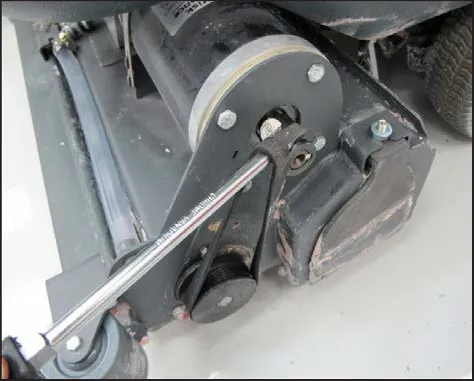A screwdriver prying the belt onto the motor pulley, first position