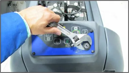 Adjustable wrench on the nut of the key switch on the blue control panel