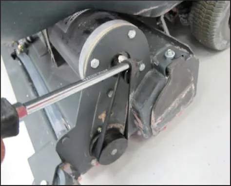 A screwdriver prying the belt onto the motor pulley, second position