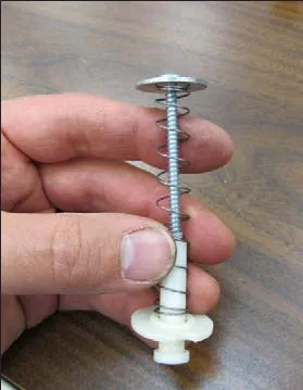Photo of a hand holding the lower stack: screw, washer, spring and nylon washer