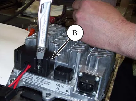 Delta-Q charger with a wrench on the black DC connector cover, arrow labeled B