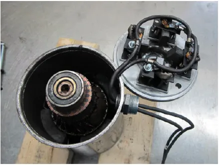 Photo of the motor with the end plate lifted off and turned beside the housing, showing the brush holders on the end plate and the armature inside.