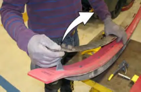 Hands removing the latch and retainer from the front of the squeegee assembly, with an arrow showing the direction