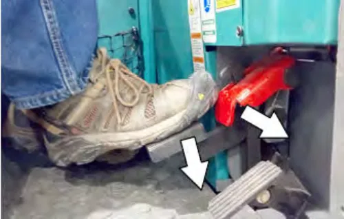 A shoe on the brake pedal with arrows pointing down at the brake pedal and at the red parking brake pedal