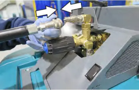 Two arrows pointing at the hose fitting and the quick connect fitting on the high pressure washer system