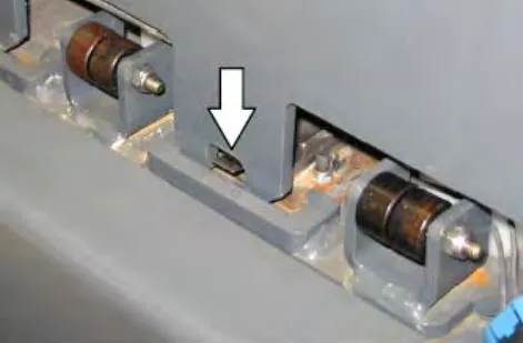 Arrow pointing down at the battery retainer plate pressing the switch into the engaged position
