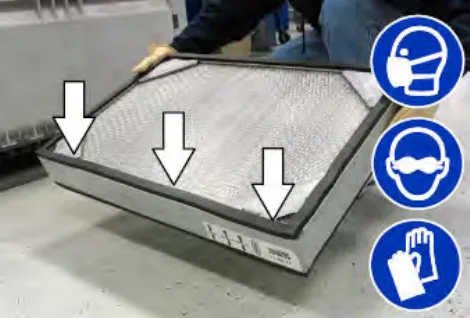 Dust filter held tilted with arrows pointing down at the dirty side, plus mask, eye protection and glove symbols