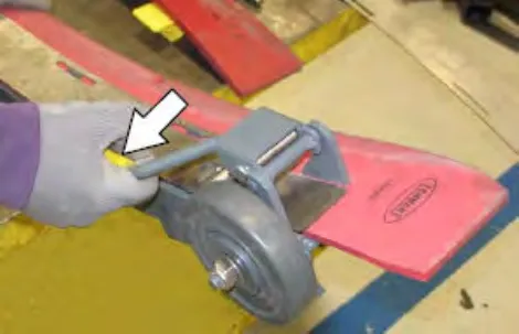 Hand fastening the retainer latch on the squeegee assembly, with an arrow pointing to the latch