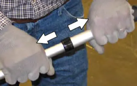 Hands extending and twisting the vacuum wand handle, with arrows showing the twist directions