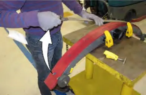 Hands removing the latch and retainer from the squeegee assembly, with an arrow showing the direction