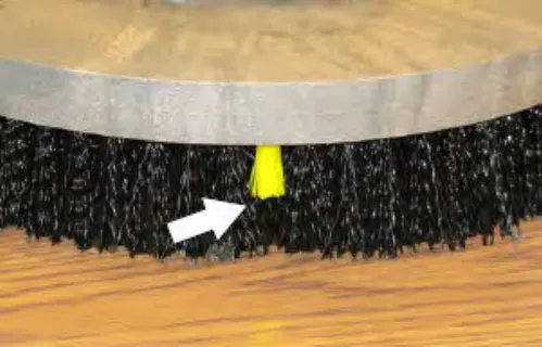 Scrubbing side brush with an arrow pointing to the yellow wear indicator bristle