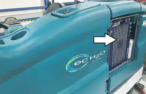 Machine side panel with an arrow pointing to the fuel cell battery access opening