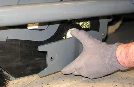 Hand removing the left brush arm