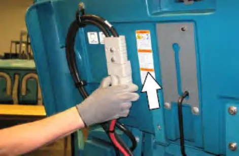 Hand pushing the battery connector up into the machine connector, with an arrow pointing up