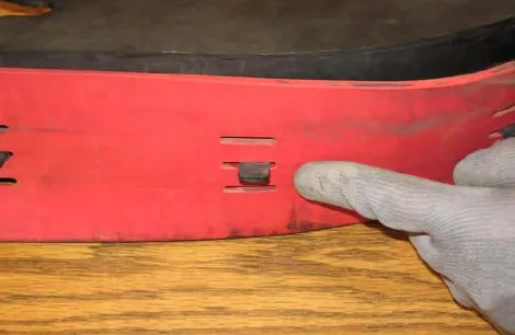 Finger pointing at a tab hooked through a hole in the squeegee blade