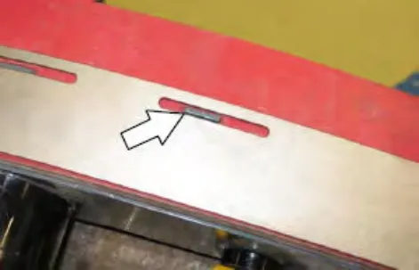 Squeegee tab aligned with a slot in the retainer, with an arrow pointing to it