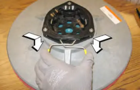 New side brush with its spring opened and arrows showing the spring handles