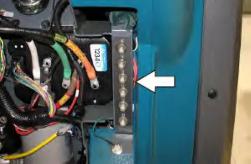 Circuit breakers 10 through 15 behind the steering shroud access panel, with an arrow pointing to the row of breakers