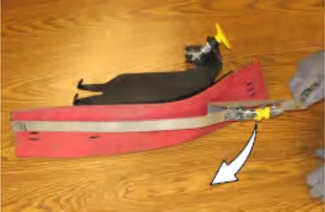 Retaining band being pulled off the side brush squeegee frame, with an arrow showing the direction