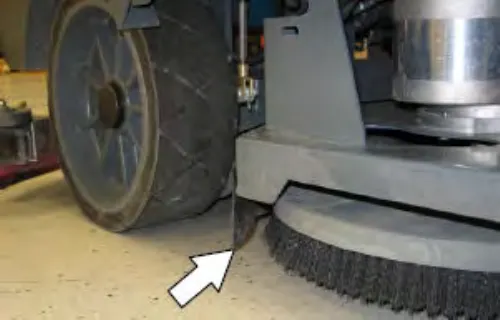 Scrub head near the front wheel with an arrow pointing to the scrub head skirt