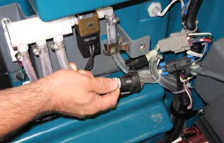 Hands disconnecting the outlet hose from the hose on the ec-H2O manifold
