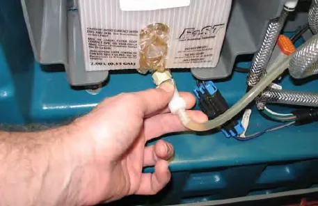 Hand squeezing the FaST supply hose connector below the carton