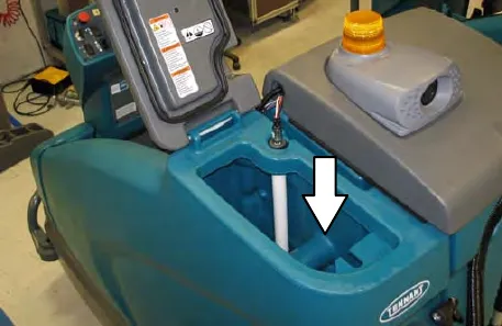 Solution tank fill opening with an arrow pointing down into it
