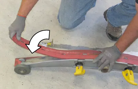 A person placing the squeegee blade onto the inner frame, with an arrow showing the direction