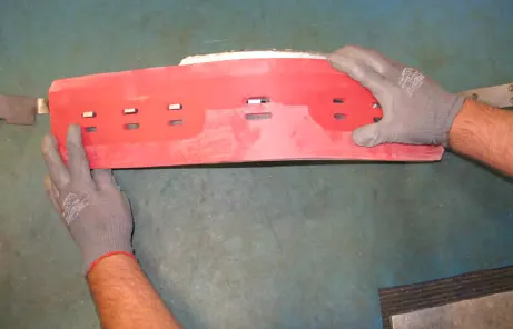 Hands holding the new squeegee blade and retainer in place on the side brush squeegee frame