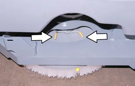Scrub head opening with arrows pointing to the two yellow spring handles