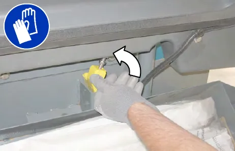 Gloved hand locking the Pre-Sweep assembly cover open