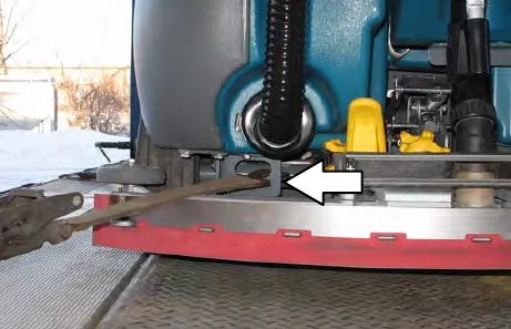 Rear of the machine with an arrow pointing to the tie-down hole in the frame