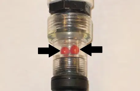 Clear flow indicator with arrows pointing to the two red balls inside