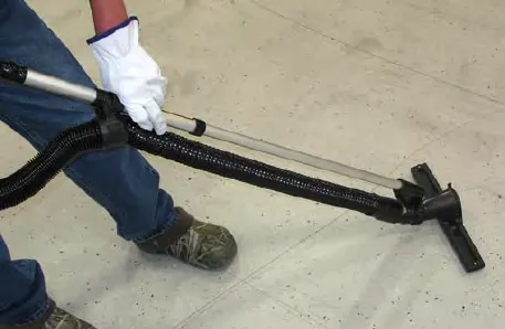 Operator vacuuming the floor with the wand
