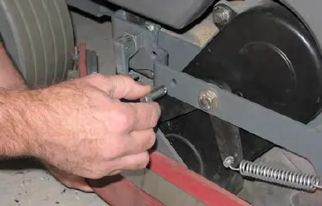 Hand reinserting a clevis pin into the side squeegee bracket
