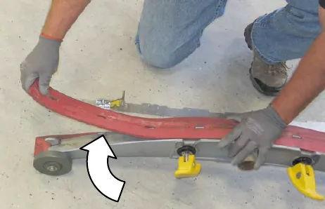A person peeling the squeegee blade off the squeegee assembly, with an arrow showing the direction