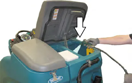 Recovery tank opened and flushed with a hose, with an arrow into the tank