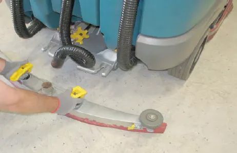 A person pulling the rear squeegee assembly out from the back of the machine
